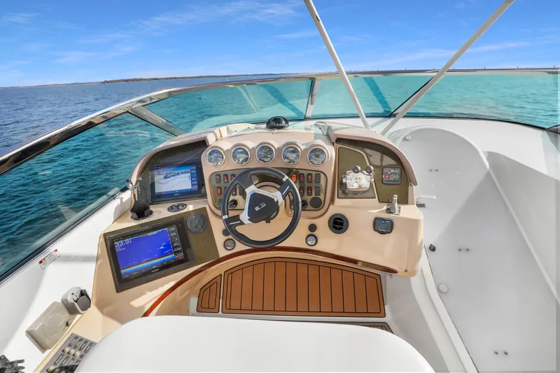 Slide: The Image of 2005 Carver 560 Voyager helm with navigation displays, steering wheel, and ocean view. - 32