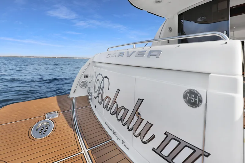 Slide: The Image of 2005 Carver 560 Voyager yacht on water, featuring teak deck and "Babalu III" name. - 36