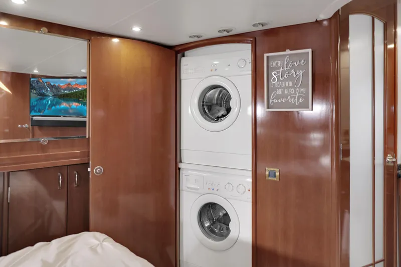 Slide: The Image of Interior of 2005 Carver 560 Voyager with stacked washer and dryer, wooden cabinetry, and wall art. - 64
