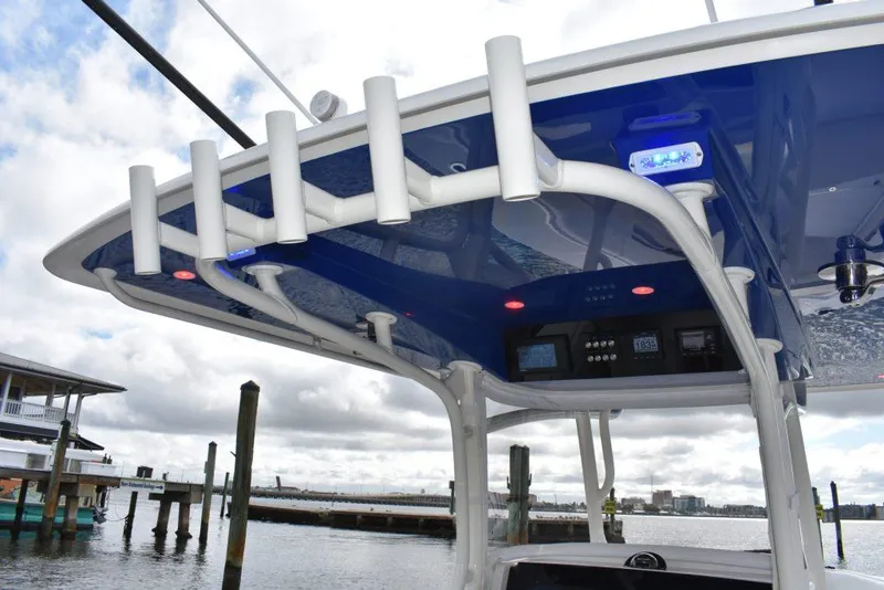 Slide: The Image of 2025 Jupiter 34 boat with blue canopy and rod holders at a marina. - 8