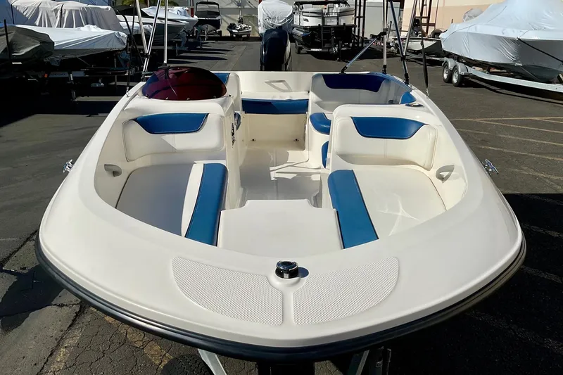 Slide: The Image of 2016 Bayliner Element boat with white and blue seating, parked in a marina. - 16
