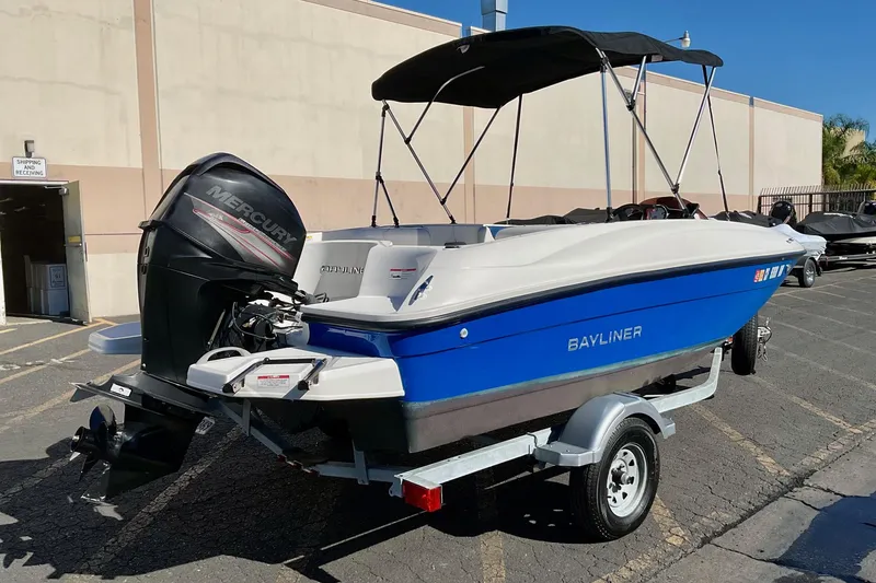 Slide: The Image of 2016 Bayliner Element boat with Mercury engine on trailer, parked outdoors. - 3