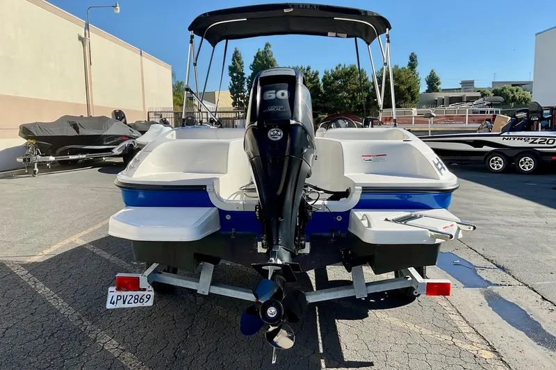 Slide: The Image of 2016 Bayliner Element boat with outboard motor on trailer in parking lot. - 4