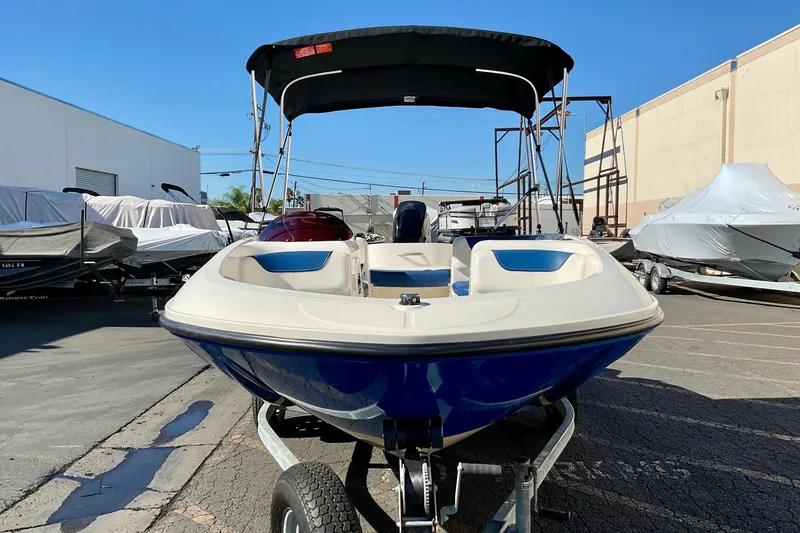 Slide: The Image of 2016 Bayliner Element boat on trailer, parked outdoors under clear blue sky. - 6