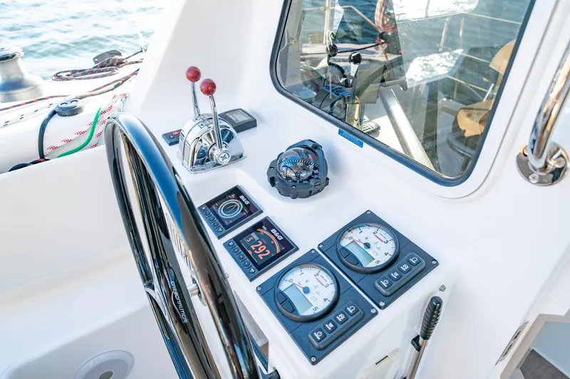 Slide: The Image of 2023 Seawind 1160 Lite cockpit with steering wheel, controls, and navigation instruments. - 11