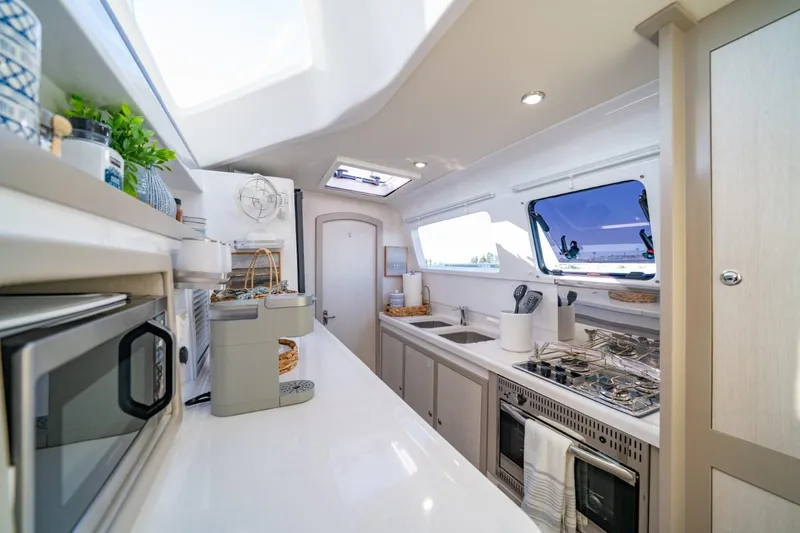 Slide: The Image of Modern kitchen interior of 2023 Seawind 1160 Lite catamaran, featuring sleek appliances and ample counter space. - 18