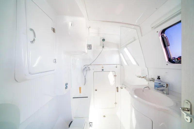 Slide: The Image of 2023 Seawind 1160 Lite yacht bathroom with shower, sink, and window. - 22