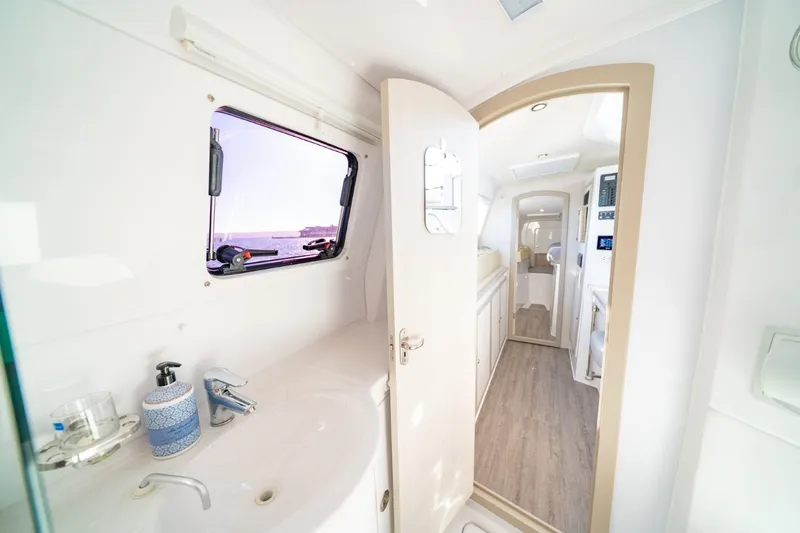 Slide: The Image of Interior of 2023 Seawind 1160 Lite catamaran, featuring modern bathroom and hallway view. - 23