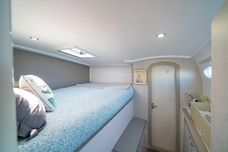 Slide: The Image of Cozy bedroom interior of 2023 Seawind 1160 Lite catamaran with skylight and modern decor. - 24