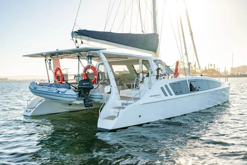Slide: The Image of 2023 Seawind 1160 Lite catamaran sailing on calm waters at sunset. - 7