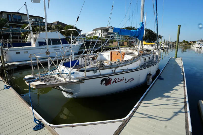 The Image of 1979 Endeavour 37 sailboat docked at marina, clear blue sky, calm water. - 0