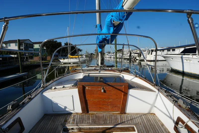 Slide: The Image of 1979 Endeavour 37 sailboat docked in a marina, featuring a wooden deck and blue sail cover. - 10