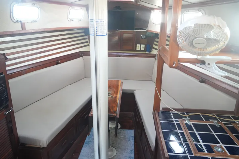 Slide: The Image of Cozy interior of 1979 Endeavour 37 sailboat with cushioned seating and wooden accents. - 12