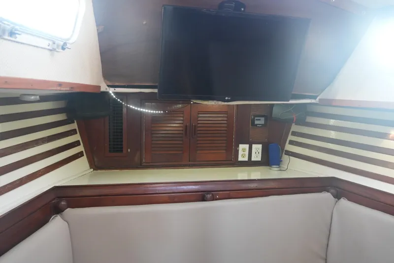 Slide: The Image of Interior of 1979 Endeavour 37 sailboat with TV, wooden cabinets, and seating area. - 13