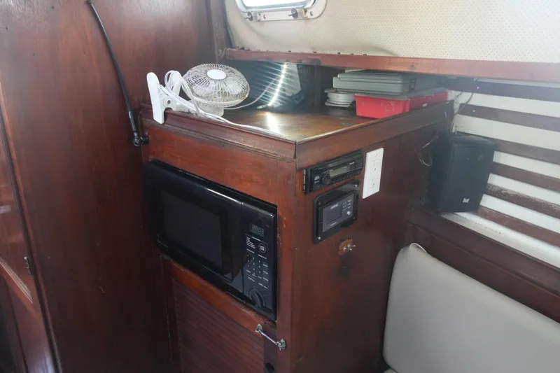 Slide: The Image of 1979 Endeavour 37 yacht interior with microwave, fan, and storage shelves. - 15