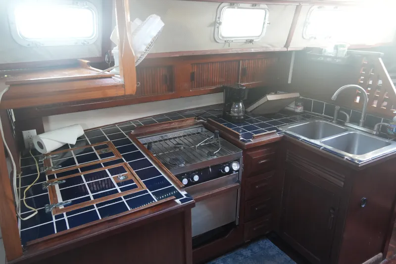 Slide: The Image of 1979 Endeavour 37 yacht kitchen with stove, sink, and tiled countertops. - 16