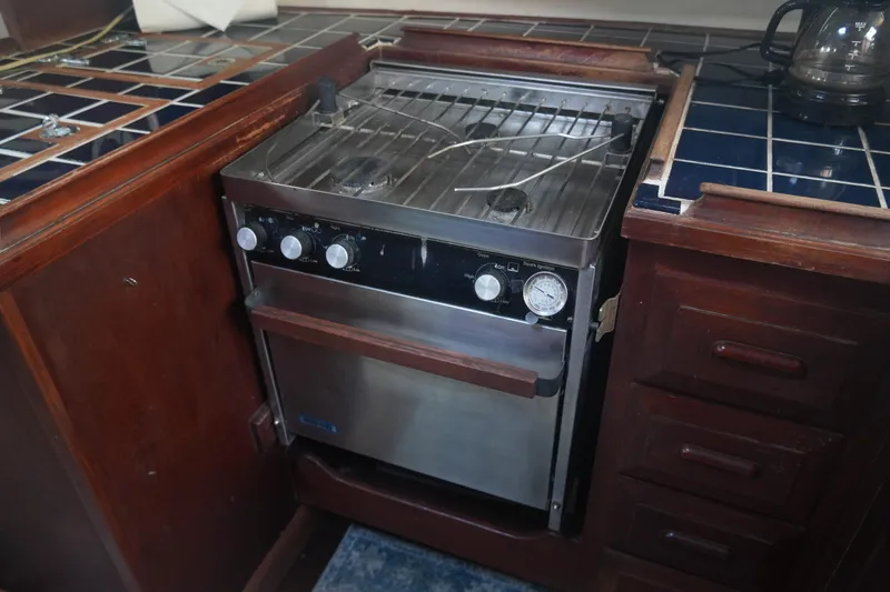 Slide: The Image of Vintage 1979 Endeavour 37 yacht kitchen with stove and wooden cabinetry. - 18