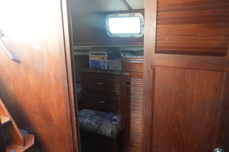 Slide: The Image of Interior of a 1979 Endeavour 37 sailboat with wooden cabinetry and storage. - 21