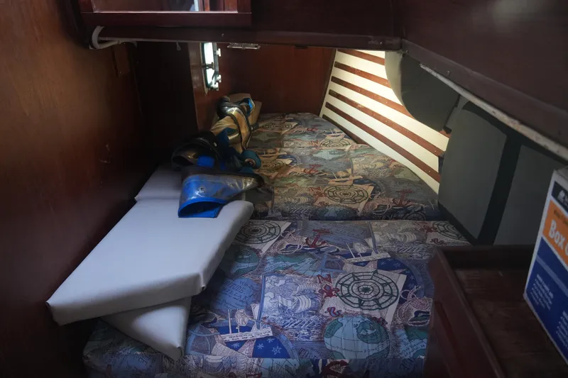 Slide: The Image of Cozy cabin interior of 1979 Endeavour 37 sailboat with nautical-themed bedding. - 22