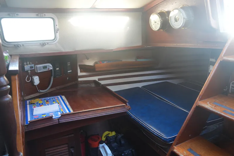 Slide: The Image of Cozy interior of 1979 Endeavour 37 sailboat with navigation station and blue cushions. - 23
