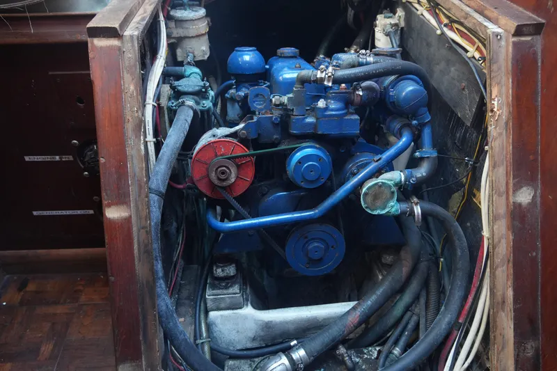 Slide: The Image of Engine compartment of a 1979 Endeavour 37 sailboat, featuring a blue marine engine. - 27
