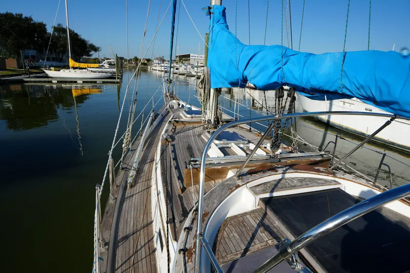 Slide: The Image of 1979 Endeavour 37 sailboat docked in a serene marina, featuring a blue sail cover. - 5