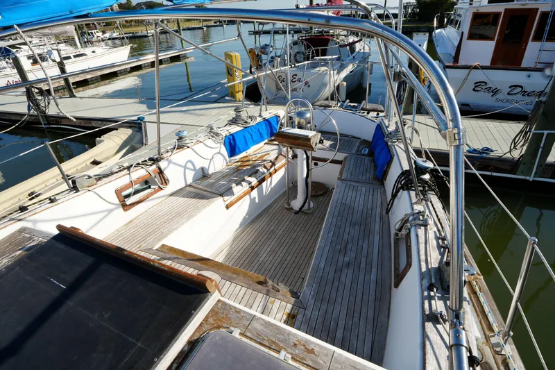 Slide: The Image of 1979 Endeavour 37 sailboat docked at marina, featuring spacious cockpit and wooden deck. - 6