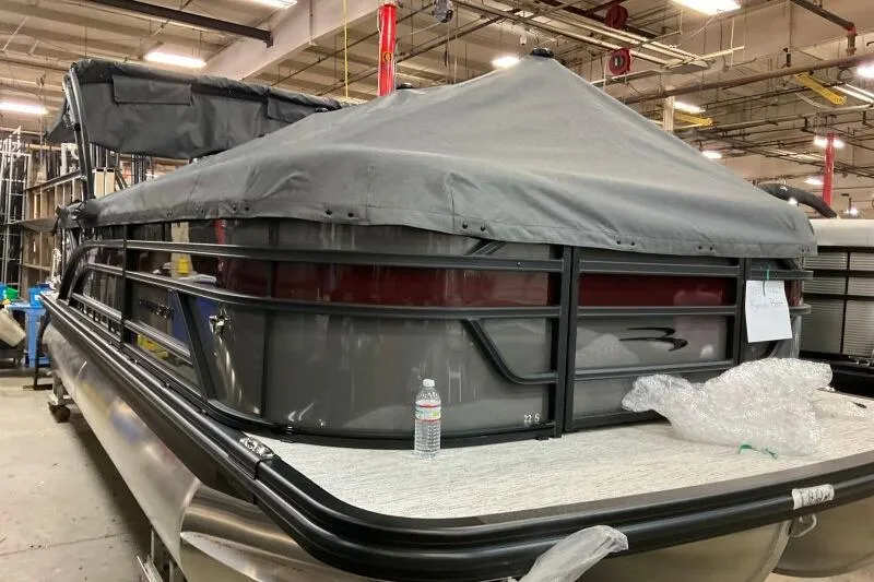 Slide: The Image of 2026 Bennington 22 SSRSE pontoon boat with cover in a warehouse setting. - 11