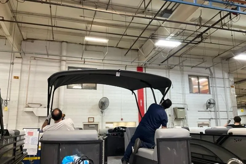 Slide: The Image of Workers assembling a 2026 Bennington 22 SSRSE pontoon boat in a factory setting. - 9