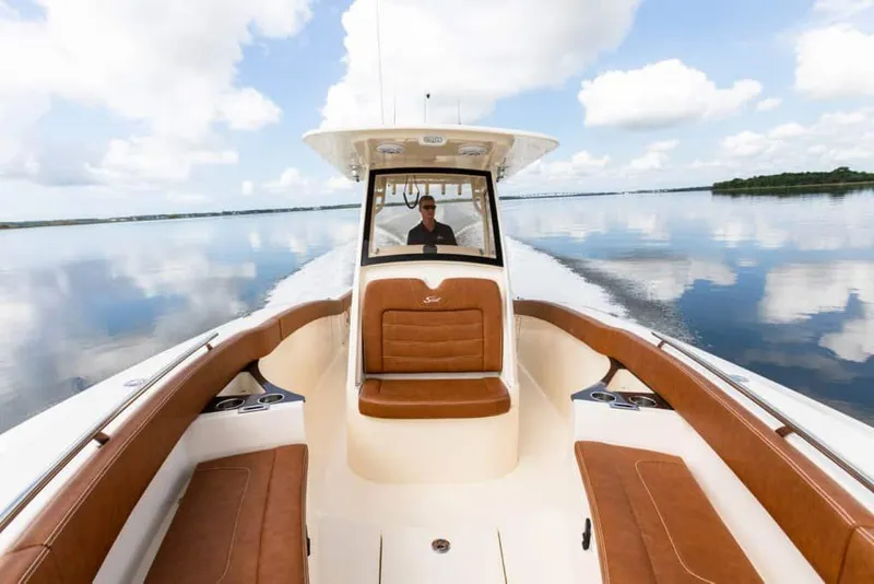 Slide: The Image of Manufacturer Provided Image: 2025 Scout 277 LXF boat cruising on calm water under a blue sky. - 5