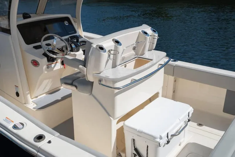 Slide: The Image of Manufacturer Provided Image: 2025 Scout 277 LXF boat interior with helm, seating, and storage, on calm water. - 8