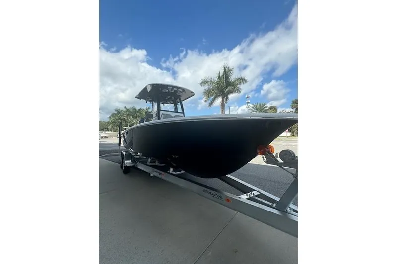 Slide: The Image of 2025 Sportsman Masters 267OE Bay Boat on trailer, under clear blue sky. - 2