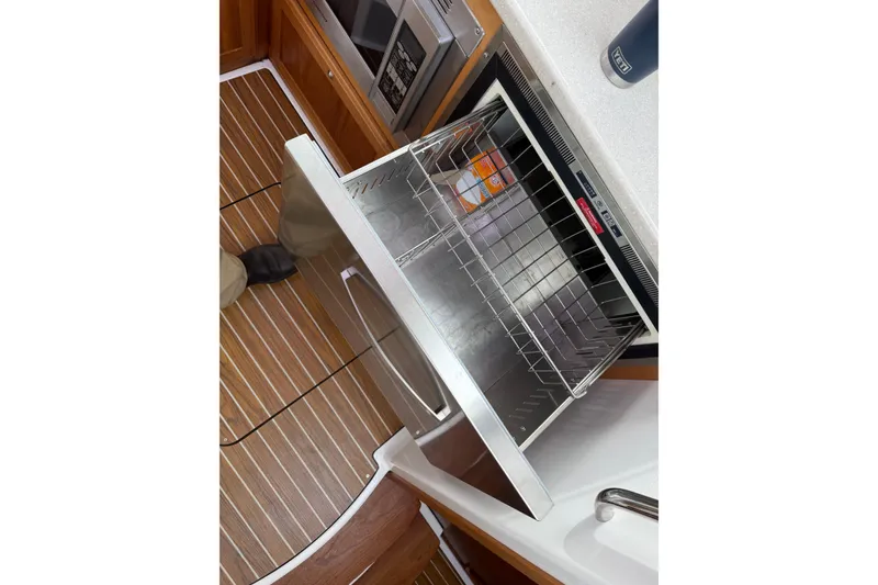 Slide: The Image of Open drawer in 2014 Back Cove 37 yacht kitchen, featuring wooden flooring and modern appliances. - 12