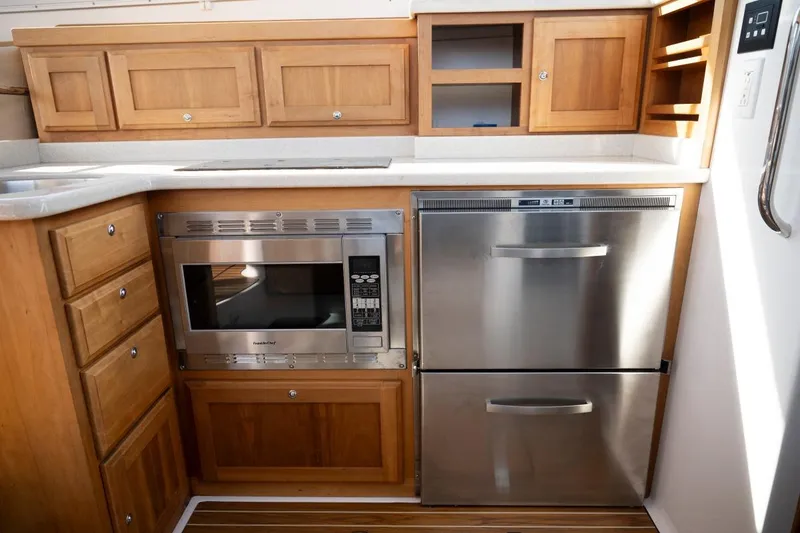 Slide: The Image of 2014 Back Cove 37 yacht kitchen with wooden cabinets, stainless steel appliances, and countertop. - 21