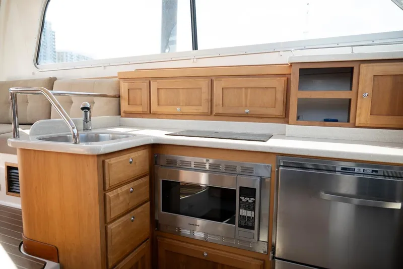 Slide: The Image of 2014 Back Cove 37 yacht kitchen with wooden cabinets, stainless steel appliances, and a sleek countertop. - 22