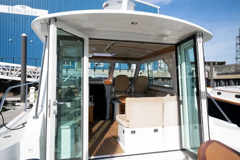 Slide: The Image of 2014 Back Cove 37 yacht interior with open sliding doors, showcasing seating and helm. - 24