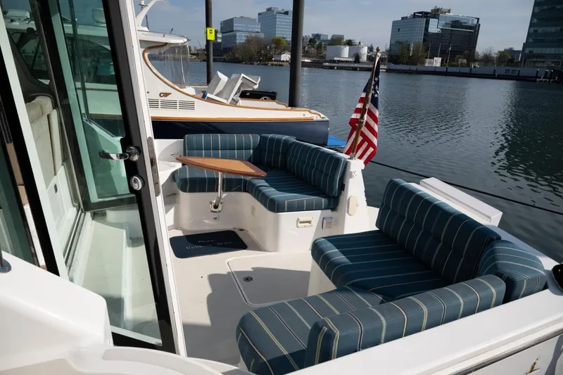 Slide: The Image of 2014 Back Cove 37 yacht with striped seating, docked by waterfront buildings. - 27