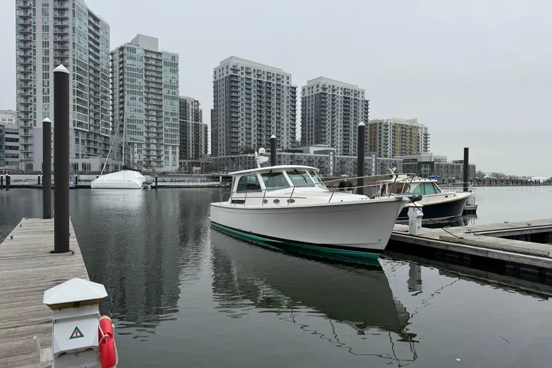 Slide: The Image of 2014 Back Cove 37 docked in urban marina with modern high-rise buildings. - 3