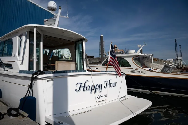 Slide: The Image of 2014 Back Cove 37 yacht named "Happy Hour" docked with American flag. - 30