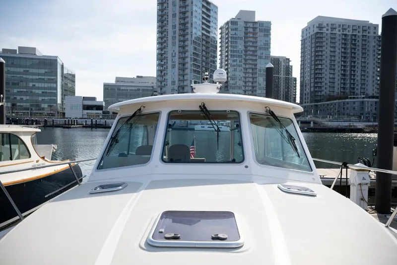 Slide: The Image of 2014 Back Cove 37 boat docked in urban marina with city skyline backdrop. - 32