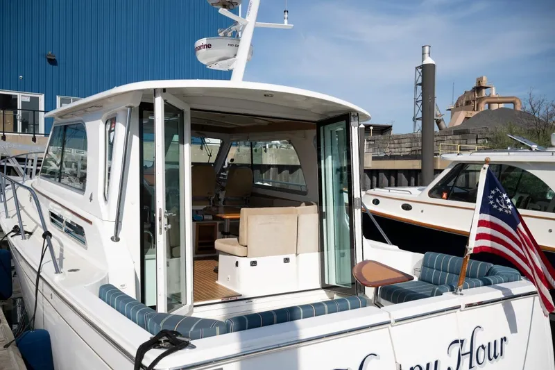 Slide: The Image of 2014 Back Cove 37 yacht docked, featuring open cabin and American flag. - 33