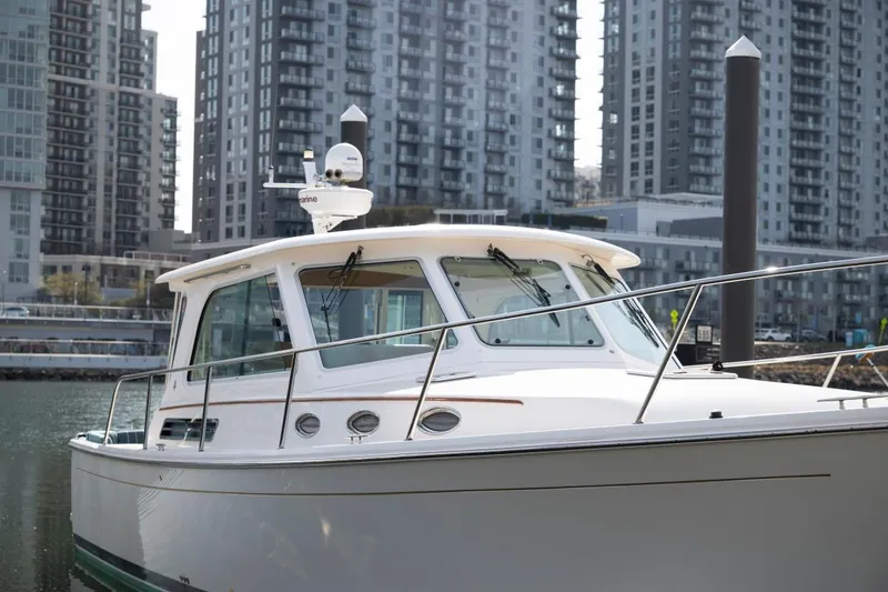 Slide: The Image of 2014 Back Cove 37 boat docked in urban marina with skyscrapers in background. - 34