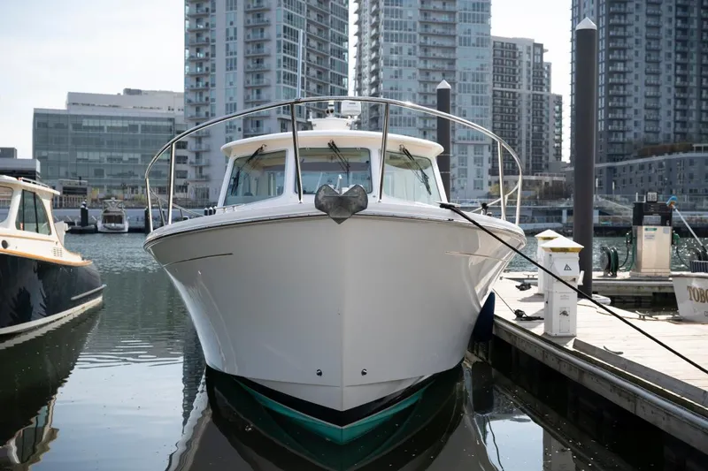 Slide: The Image of 2014 Back Cove 37 boat docked in urban marina with cityscape background. - 35