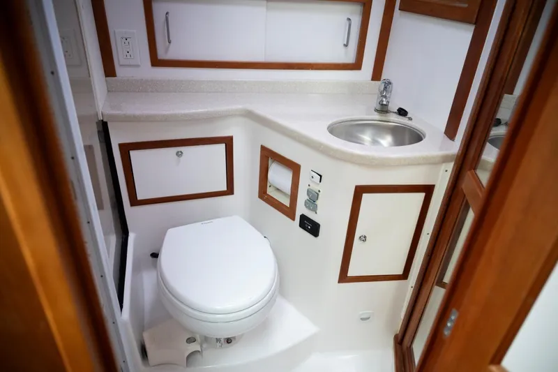 Slide: The Image of 2014 Back Cove 37 yacht bathroom with toilet, sink, and storage cabinets. - 45