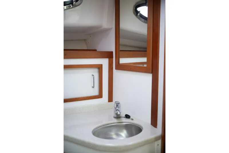Slide: The Image of 2014 Back Cove 37 yacht bathroom with sink, mirror, and wooden accents. - 46
