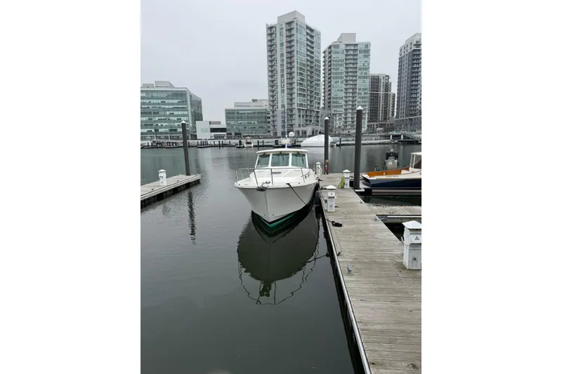 Slide: The Image of 2014 Back Cove 37 boat docked in urban marina with modern buildings. - 5