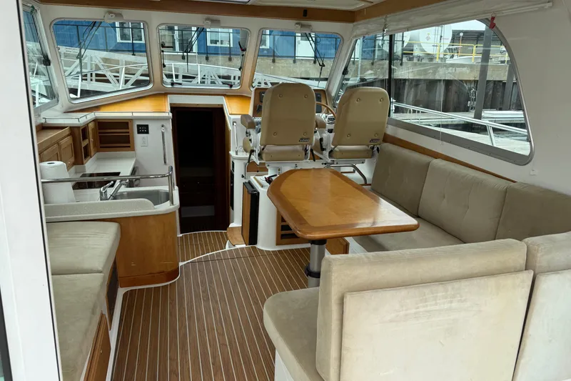 Slide: The Image of 2014 Back Cove 37 yacht interior with beige captain chairs and wooden table. - 7