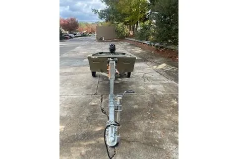 Slide: The Image of 2025 Tracker Grizzly 14 Jon boat on trailer in parking lot. - 2