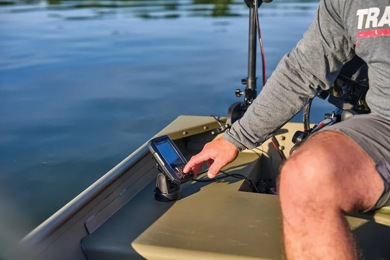 Slide: The Image of Manufacturer Provided Image: Man operating a device on a 2025 Tracker Grizzly 14 Jon boat on calm water. - 46