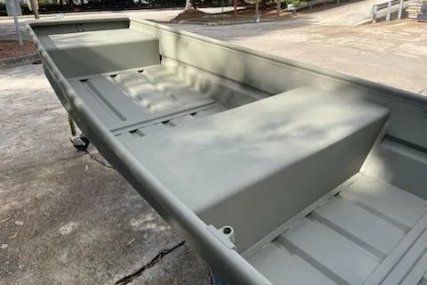 Slide: The Image of 2025 Tracker Grizzly 14 Jon boat on concrete surface, showcasing spacious interior design. - 58